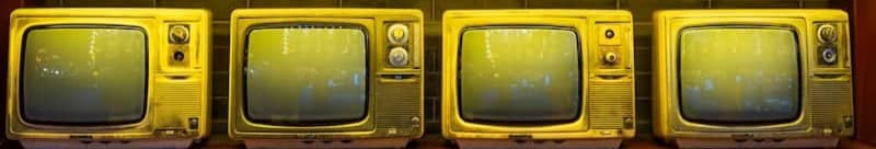 Rows of vintage televisions displayed on shelves.