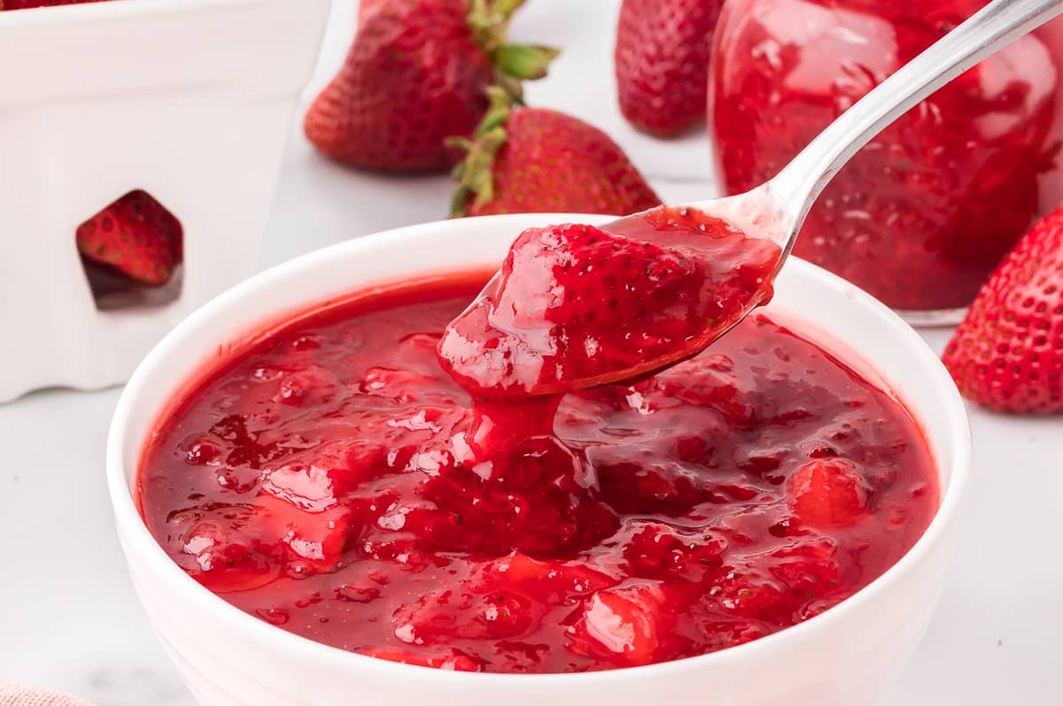 Strawberry sauce in a bowl with a spoon.