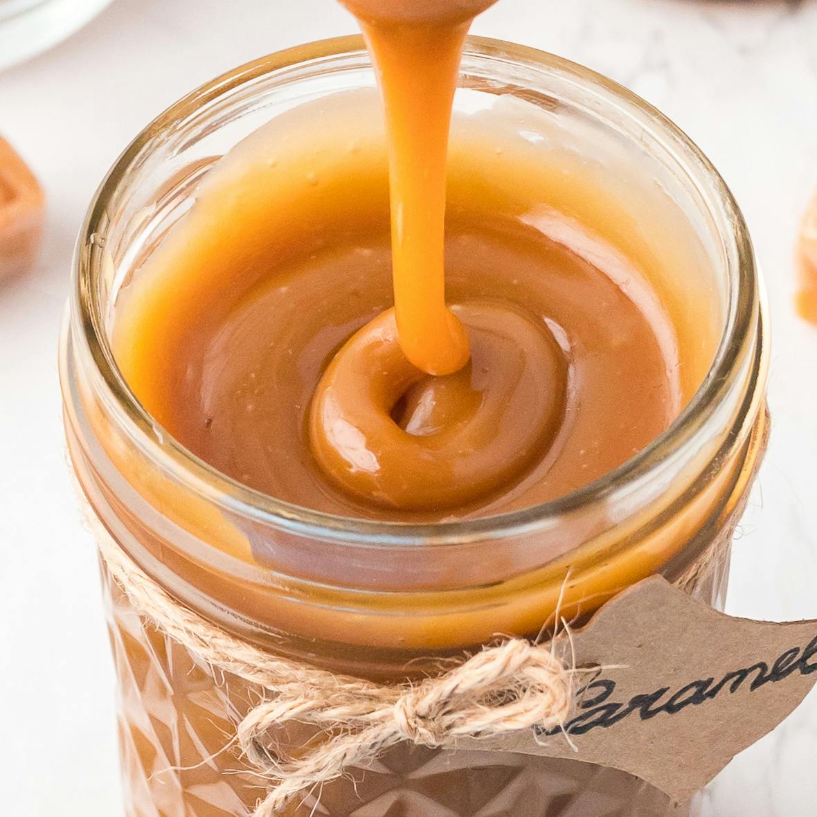 Caramel sauce drizzled into a jar.