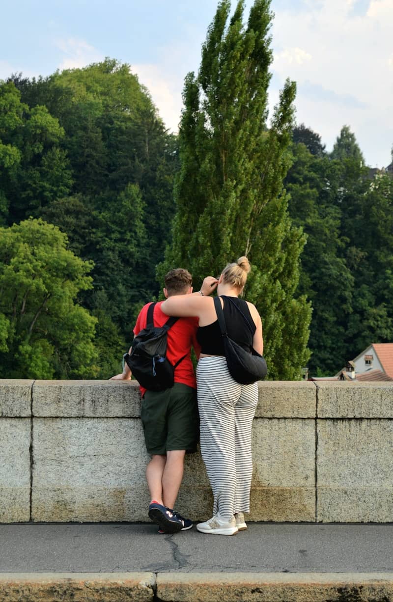 Couple embracing on a stone bridge with trees
