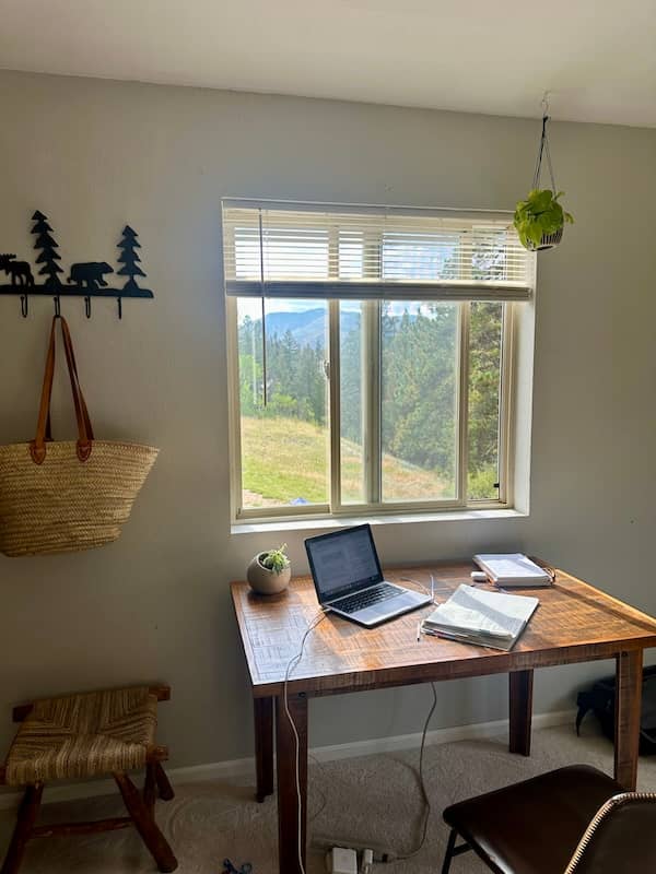 Home office space with a laptop on a desk with mountain view.