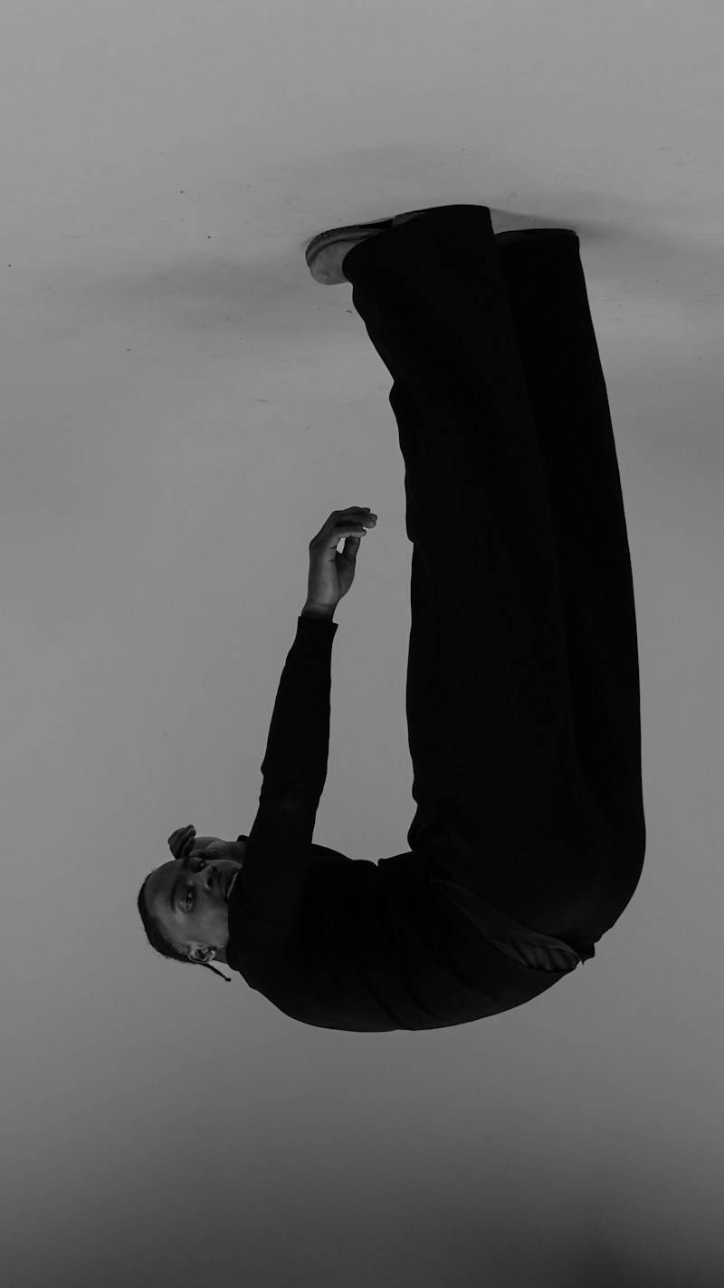A person in black clothing suspended upside down