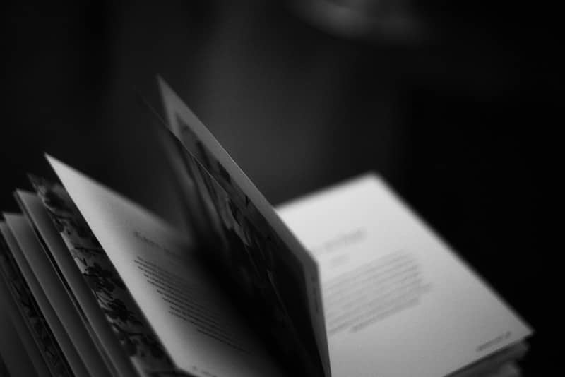 Pages of an open book being turned, black and white.