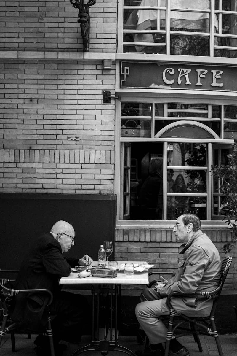 Two men sitting at a cafe table outdoors