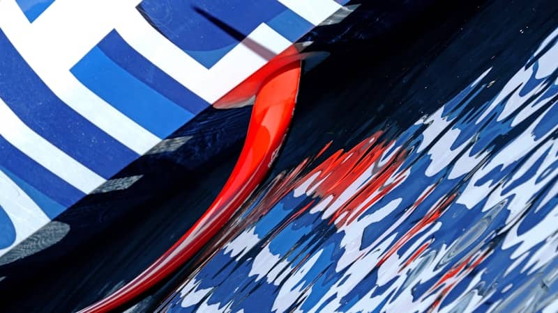 A red fin on a blue and white patterned surface reflecting in water