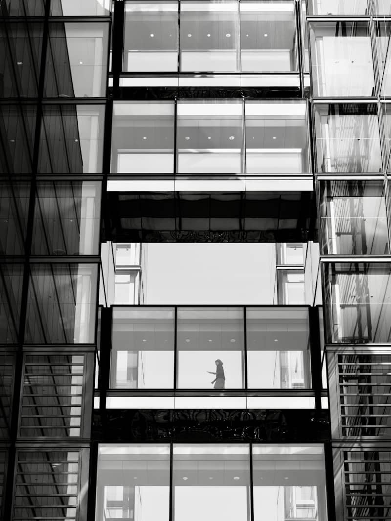 Woman walking through modern office building windows