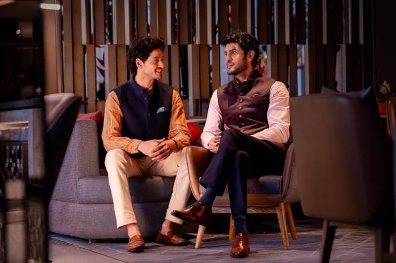 A couple of men sitting on top of a couch