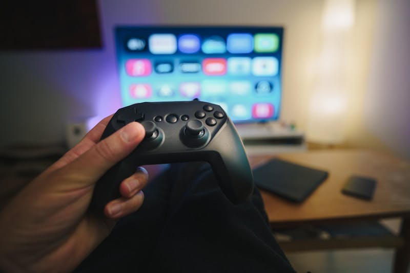 A person holding a video game controller in front of a computer