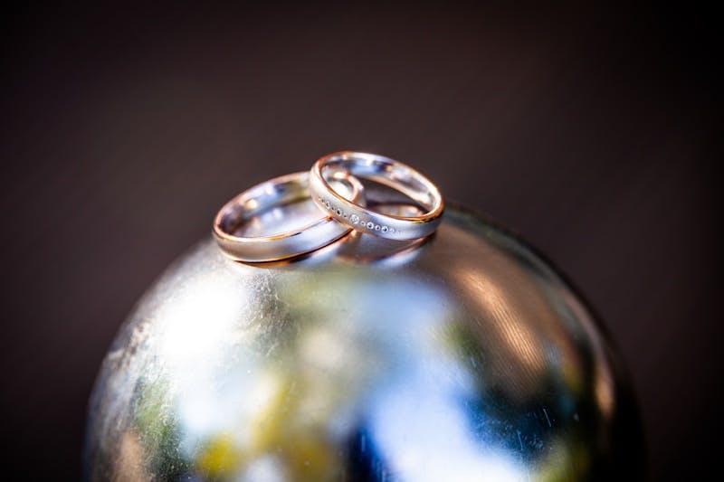 Two wedding rings sitting on top of a globe