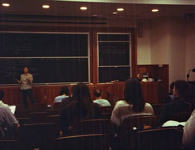 A group of people sitting in front of a blackboard