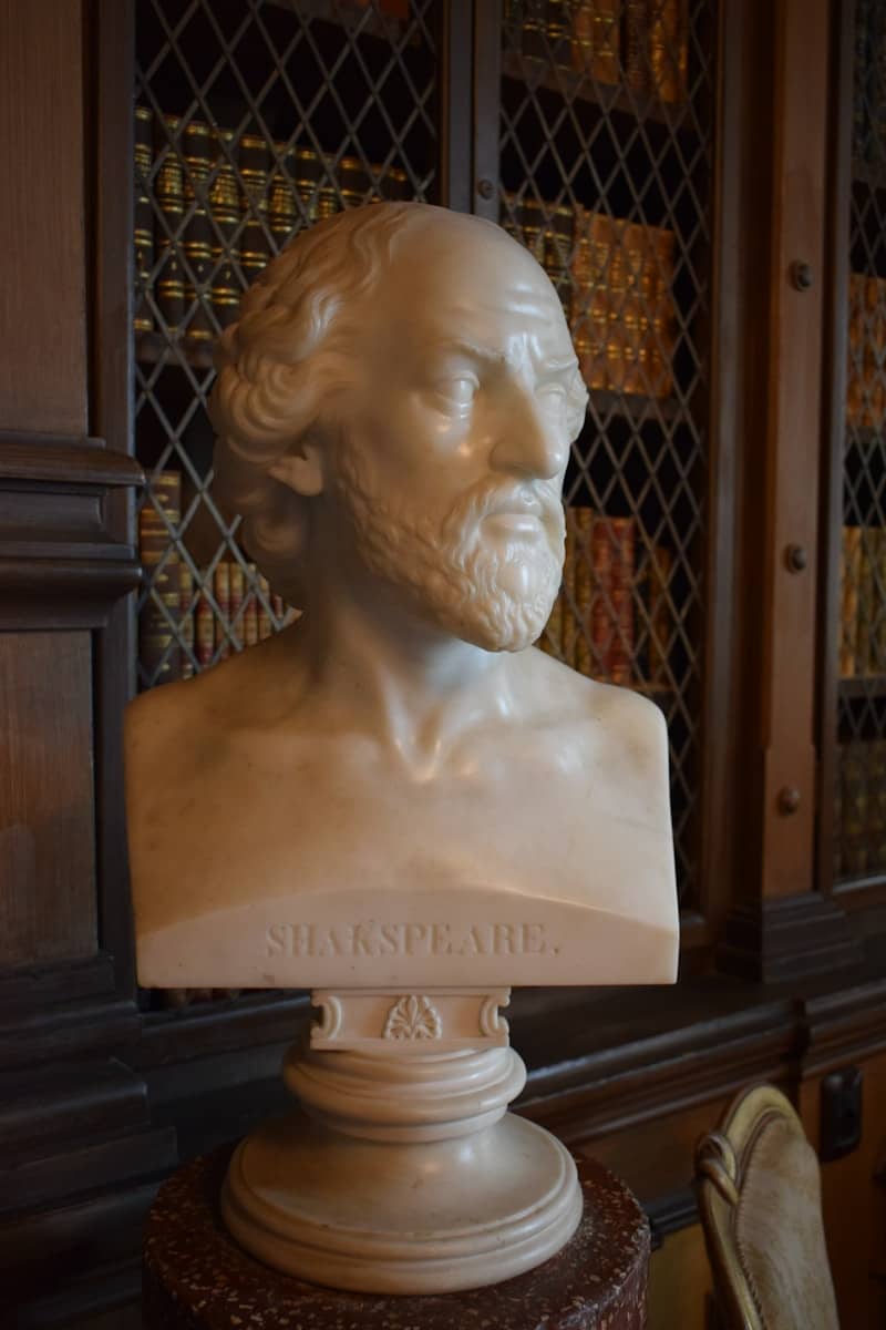 Marble bust of shakespeare in a library setting.