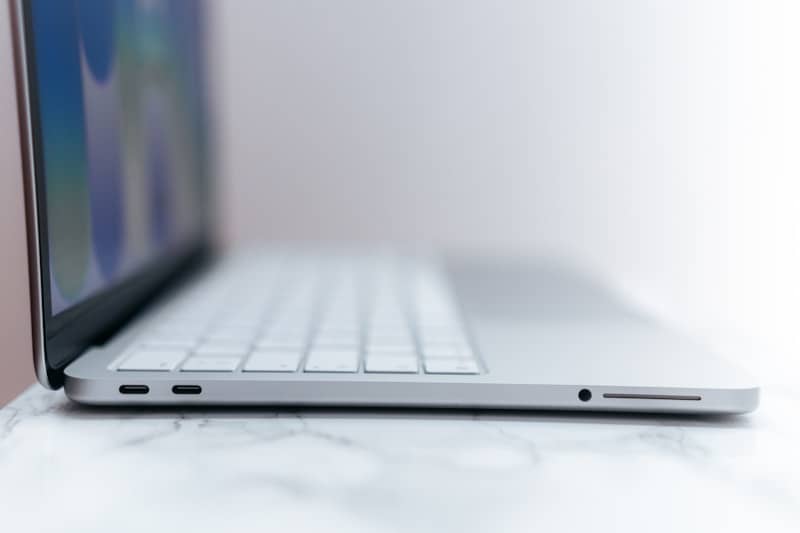 Side view of a silver laptop with white keyboard