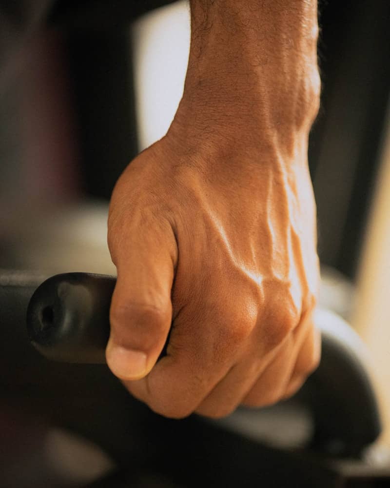Man's hand gripping a dark textured handle
