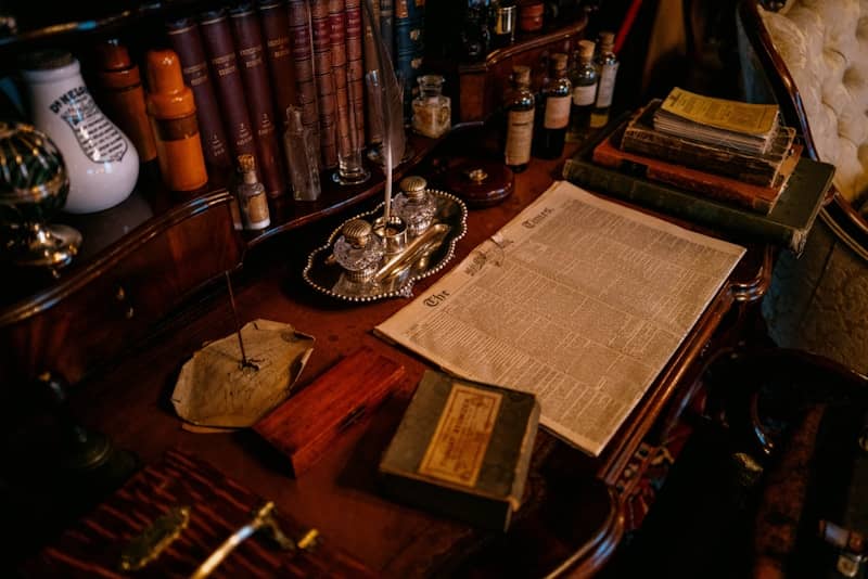 Old desk with books, inkwell, and papers.