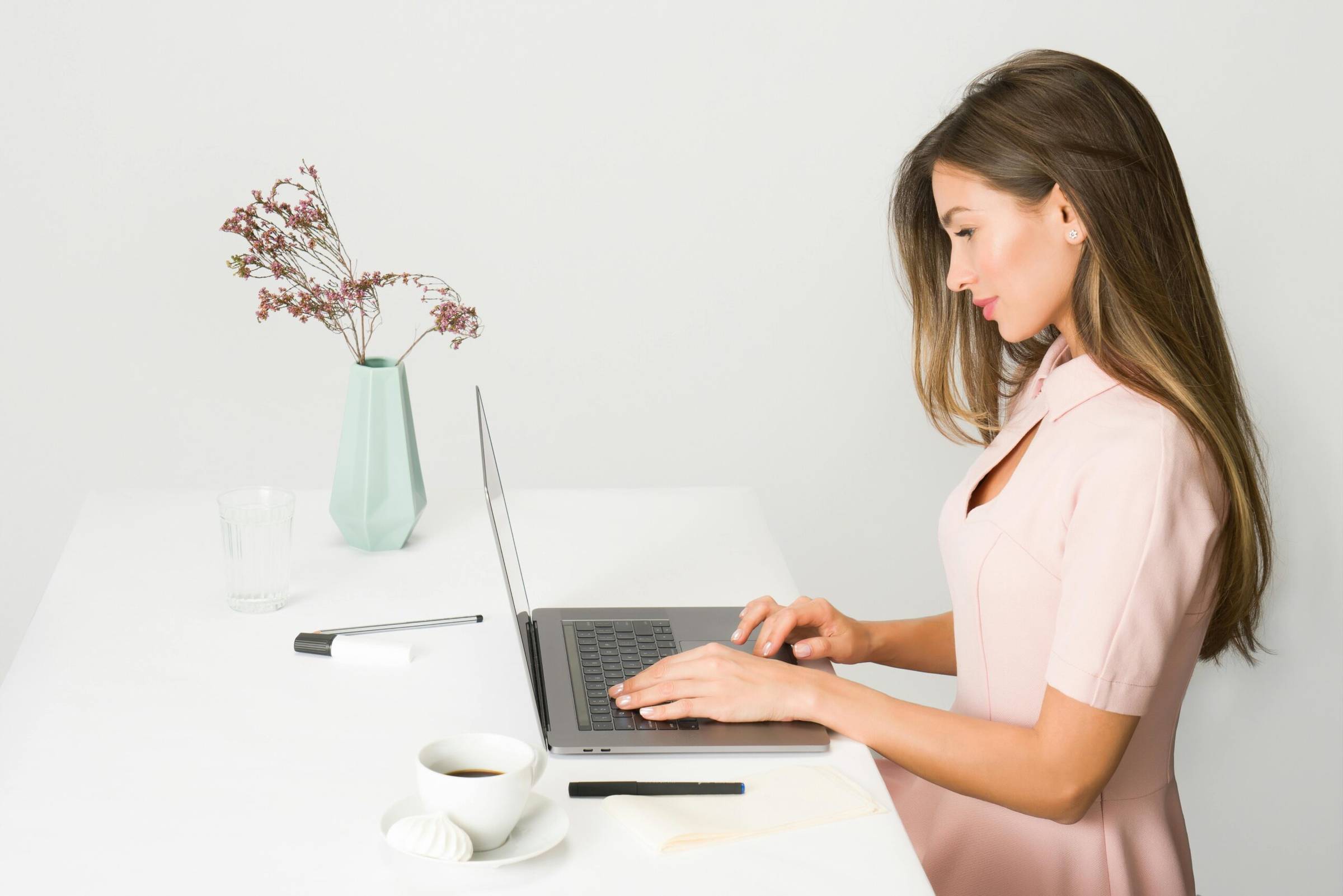 Woman working quietly at a laptop, illustrating focused work and a calm, intentional start to a meaningful task.