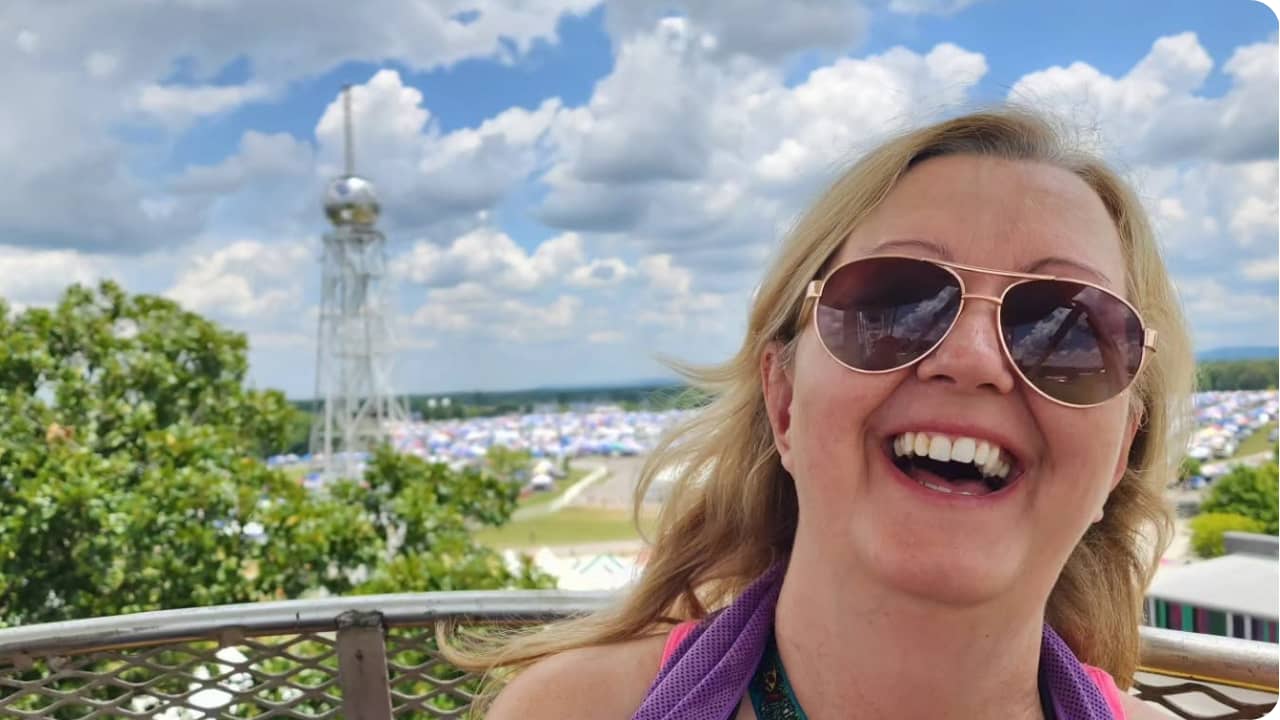 Cathy Ferringo smiling on a Ferris wheel overlooking Bonnaroo Music Festival.