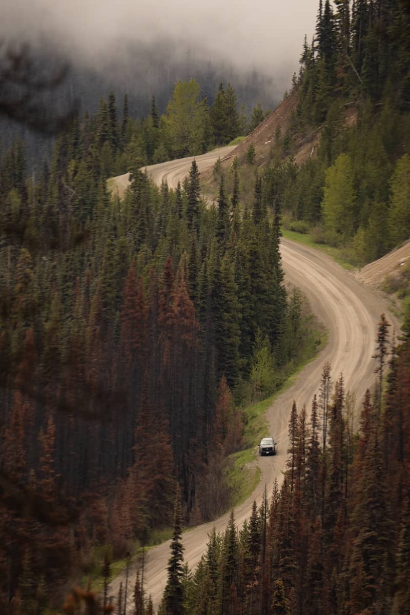 A winding road through a forested mountain.