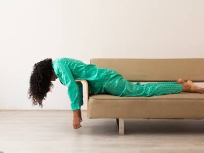 woman looking exhausted in a green pajama pant suit