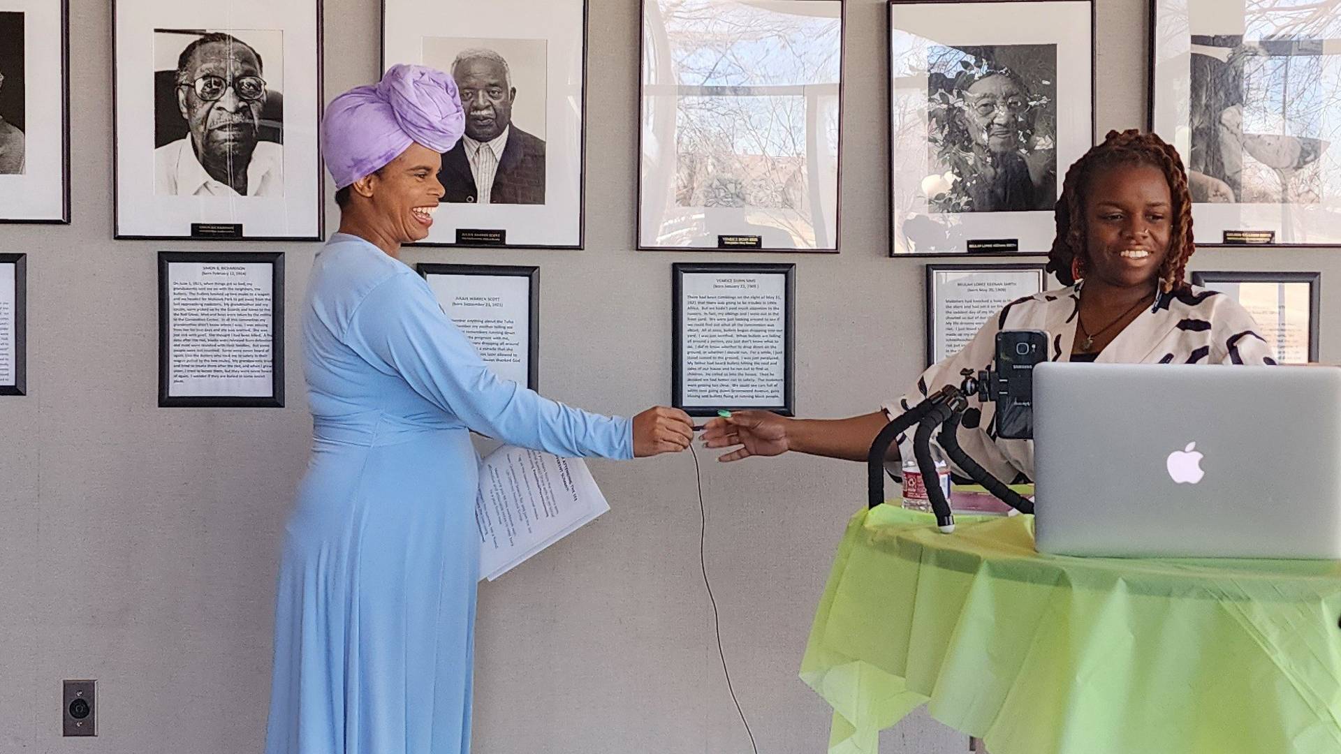 zaakirah handing a microphone to a black woman speaker