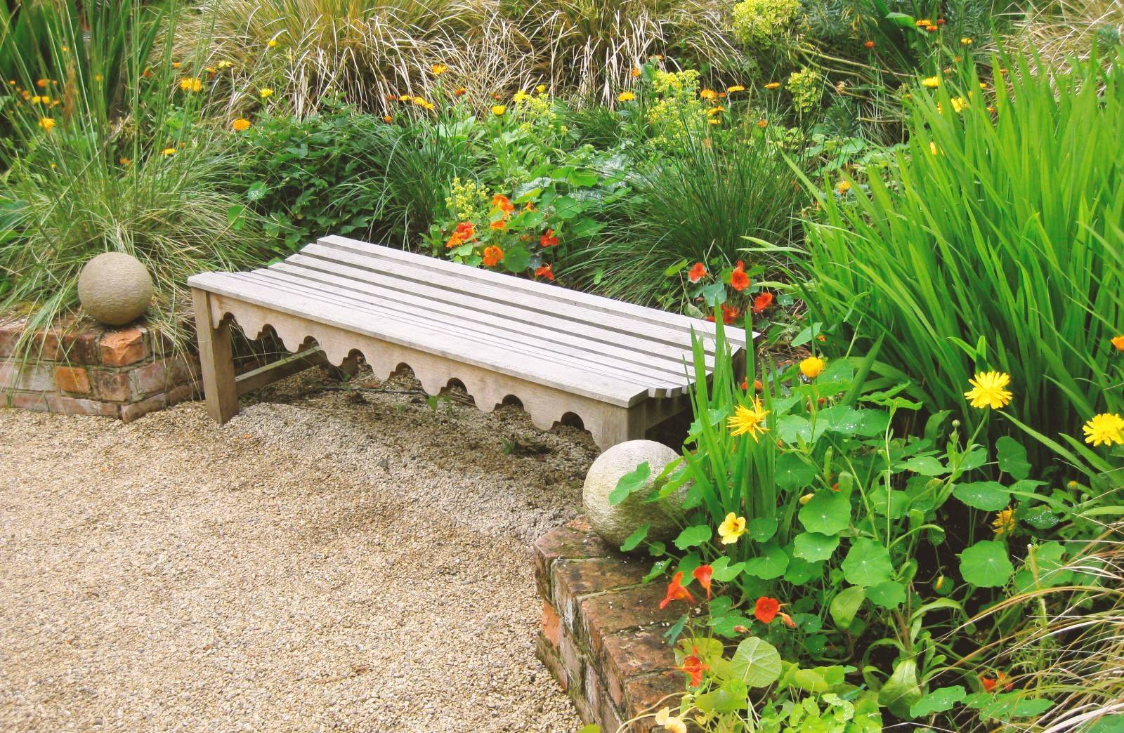 Eine Holzbank in einer ungestörten Ecke im Garten