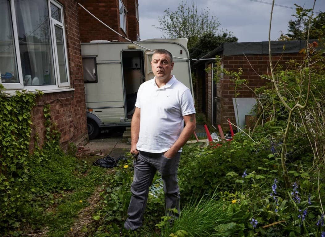 Stuart Potts standing in a yard next to a house in front of a camper trailer