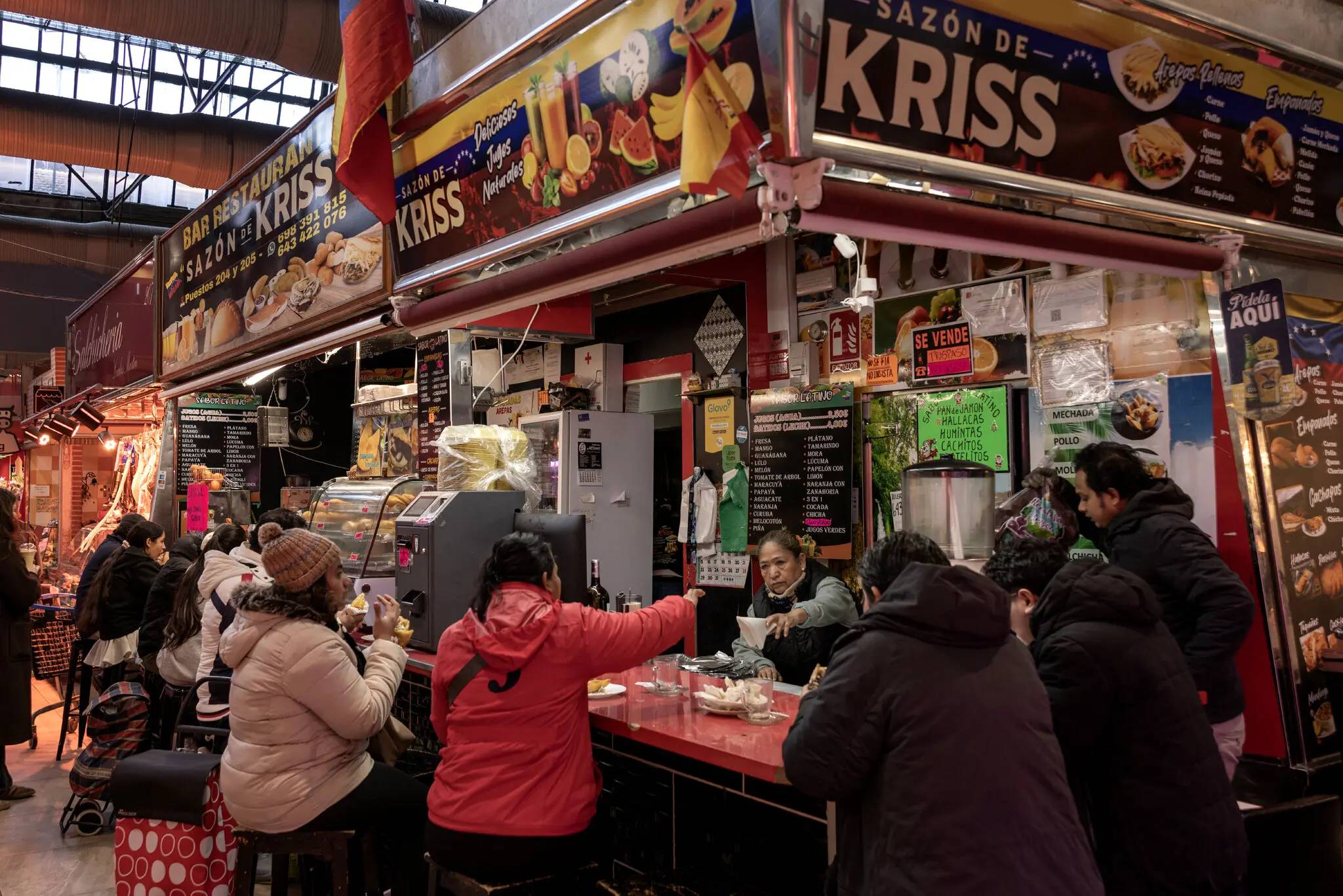 A Venezuelan food stand with people sitting at the counter