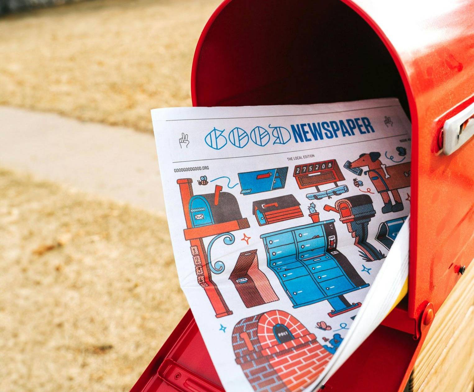 A paper copy of the Goodnewspaper in a red mailbox