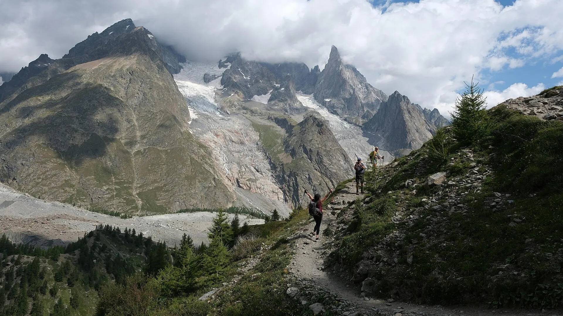 People hiking along a forested moutnain range