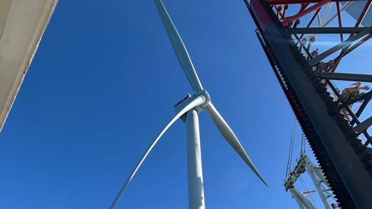 Wind turbine blades pictured from below against a blue sky