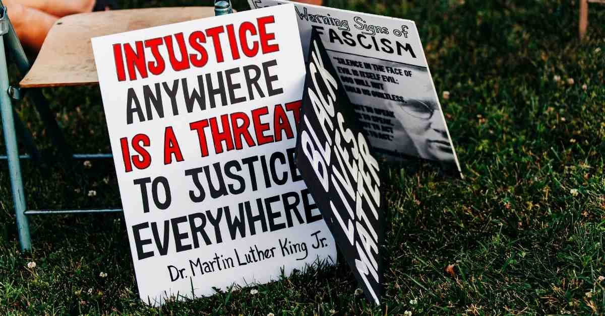 Signs on a grassy ground, one says "Injustice anywhere is a threat to justice everywhere, Dr. Martin Luther King Jr."