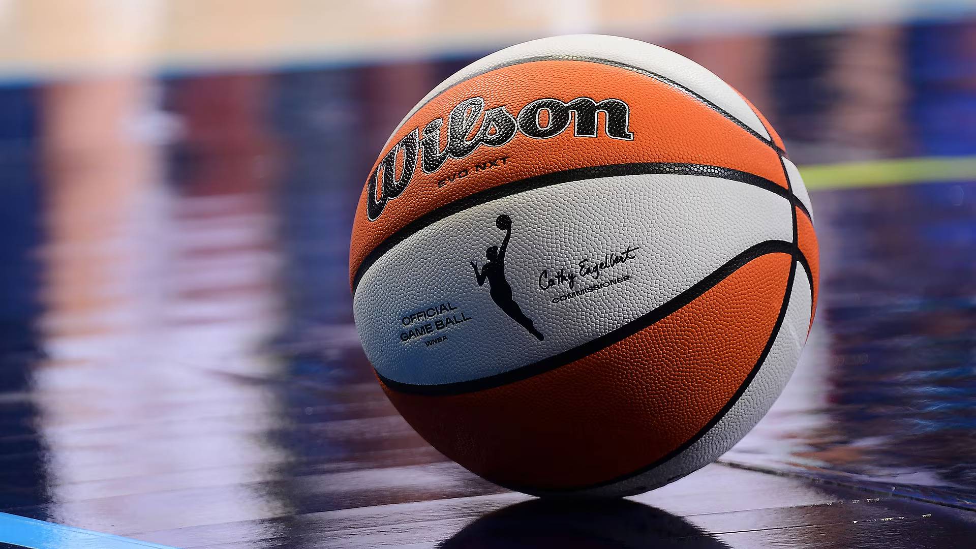 Orange and white official WNBA basketball sitting on a court
