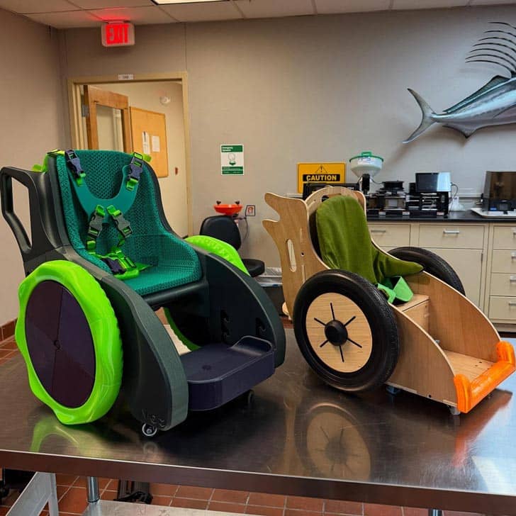 Two kid-size wheelchairs sitting on a table top