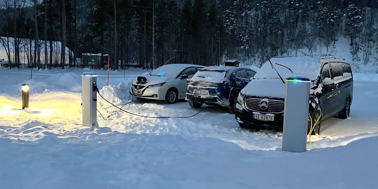 Three cars charging in the snow