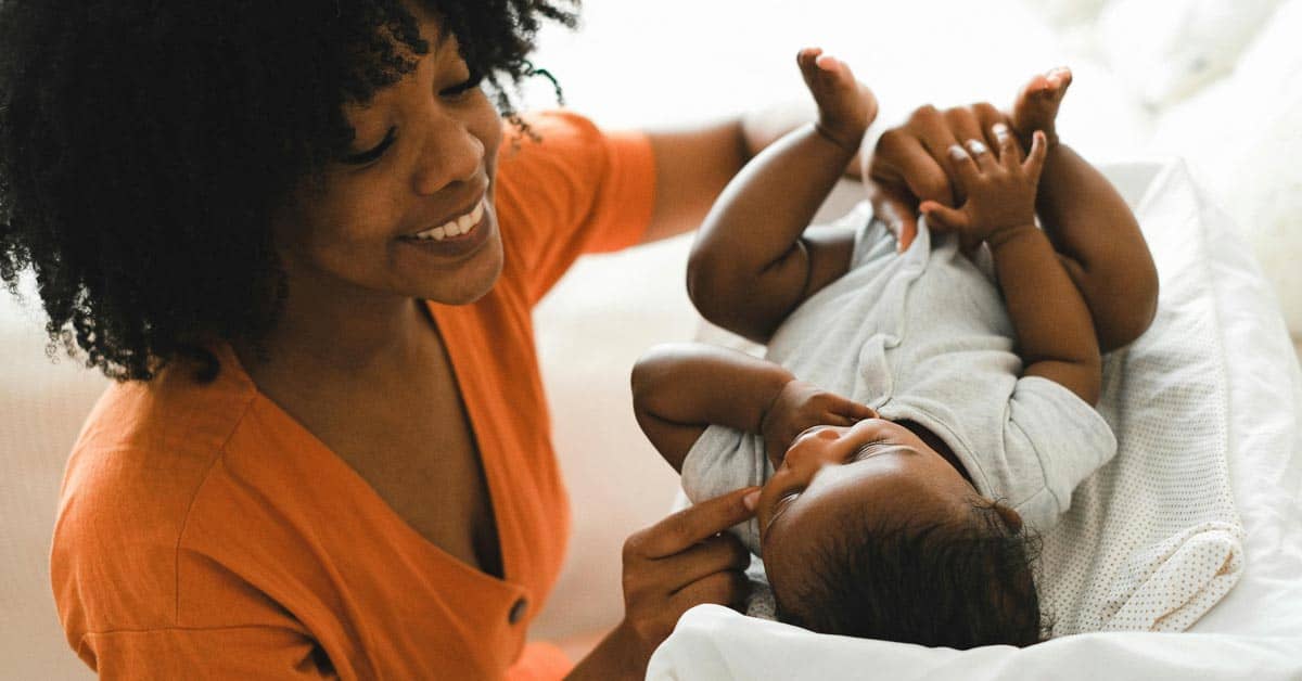 Mother smiling at a baby laying down