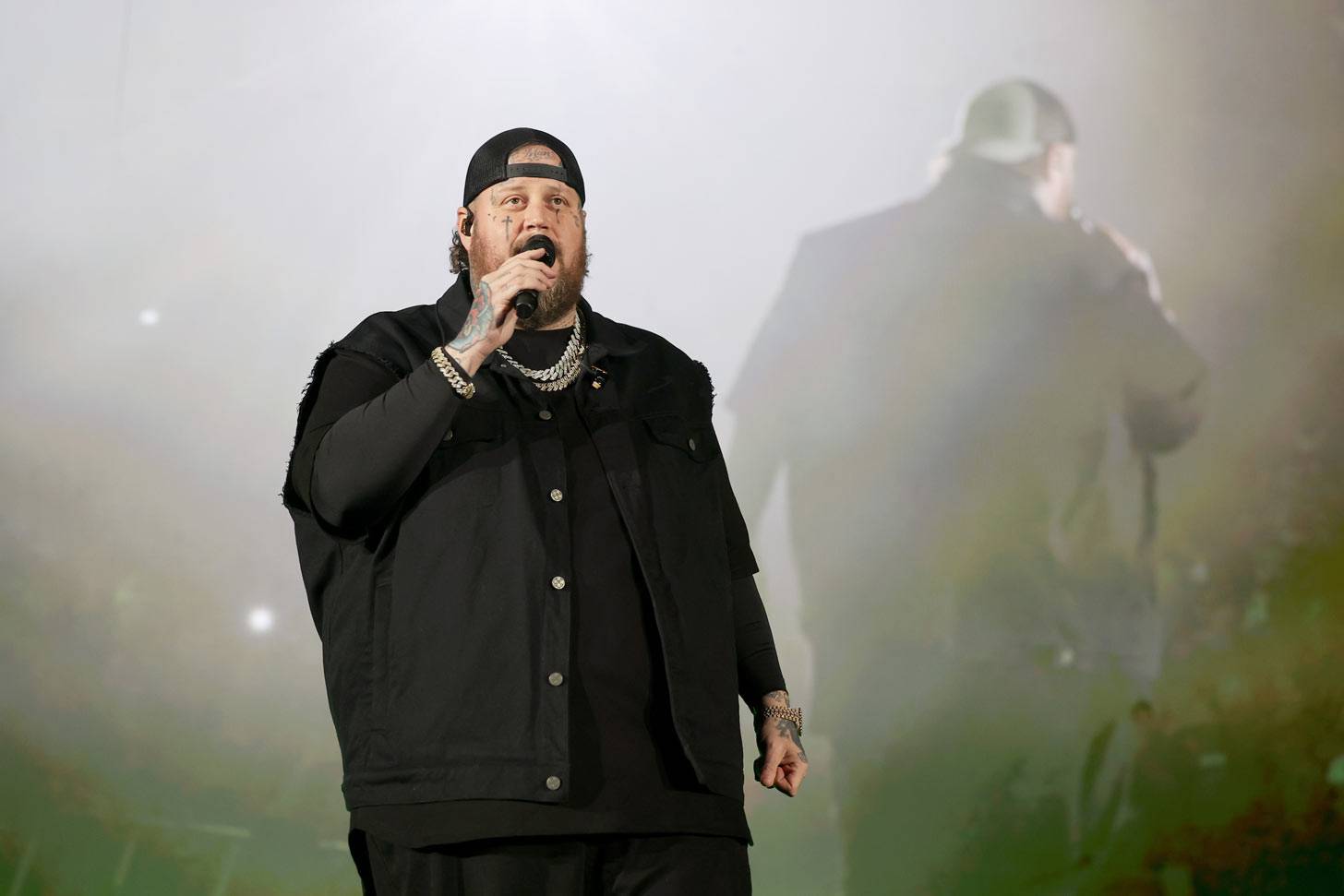 Jelly Roll on stage singing into a microphone