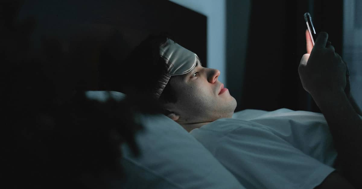 Person laying in bed looking at phone
