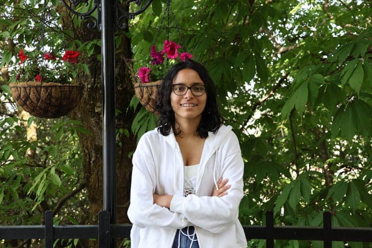 Priyanshi Poddar with greenery behind her