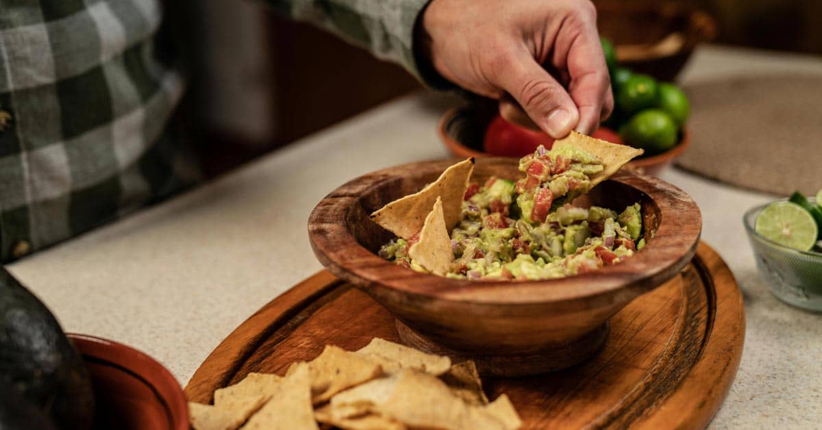Person scooping guac onto a chip