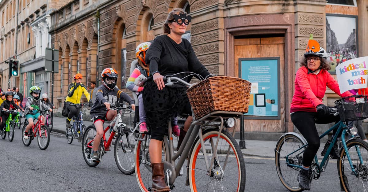 A group of people, including children, biking down a street