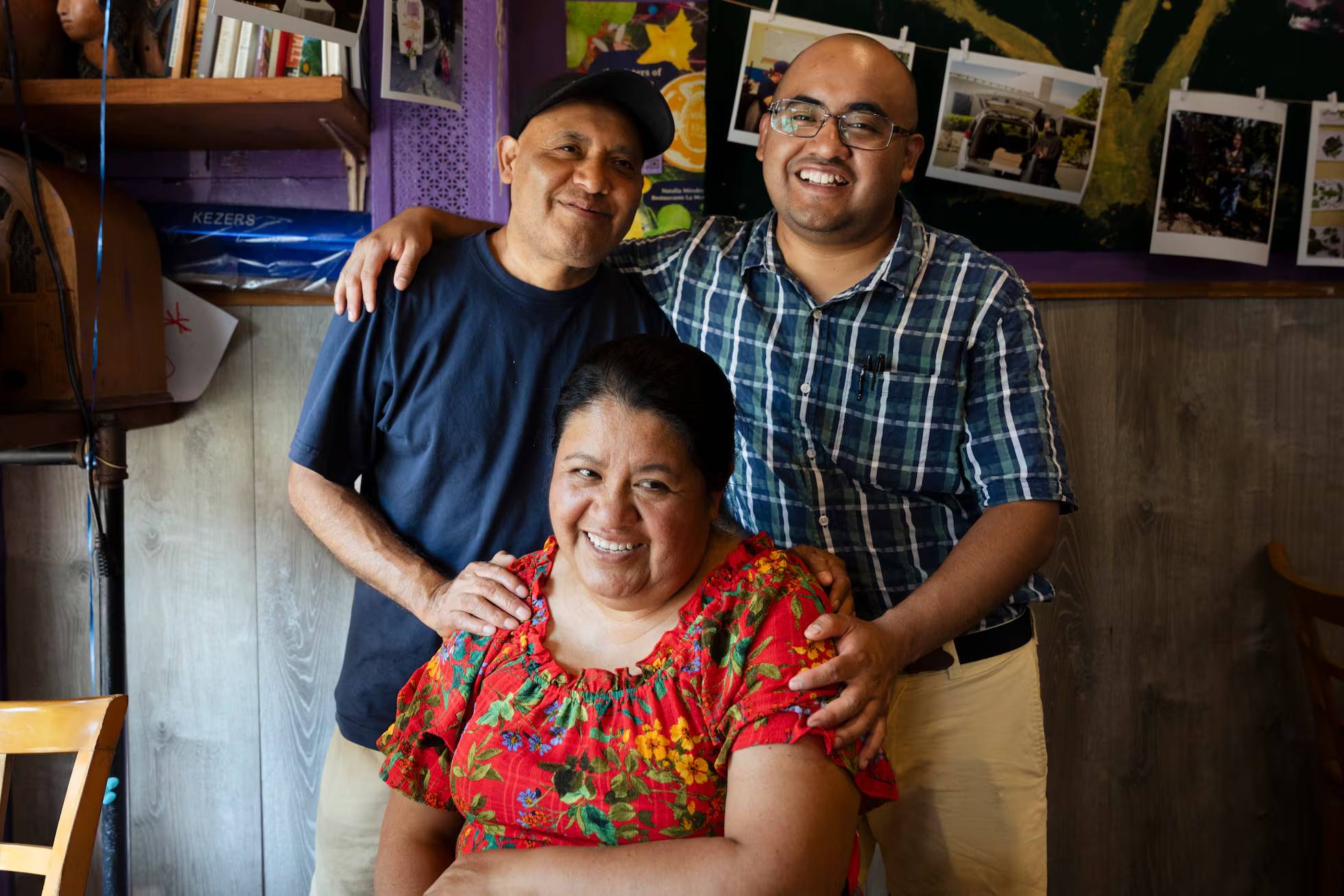 The Méndez-Saavedra family posing for the camera smiling inside their restaurant