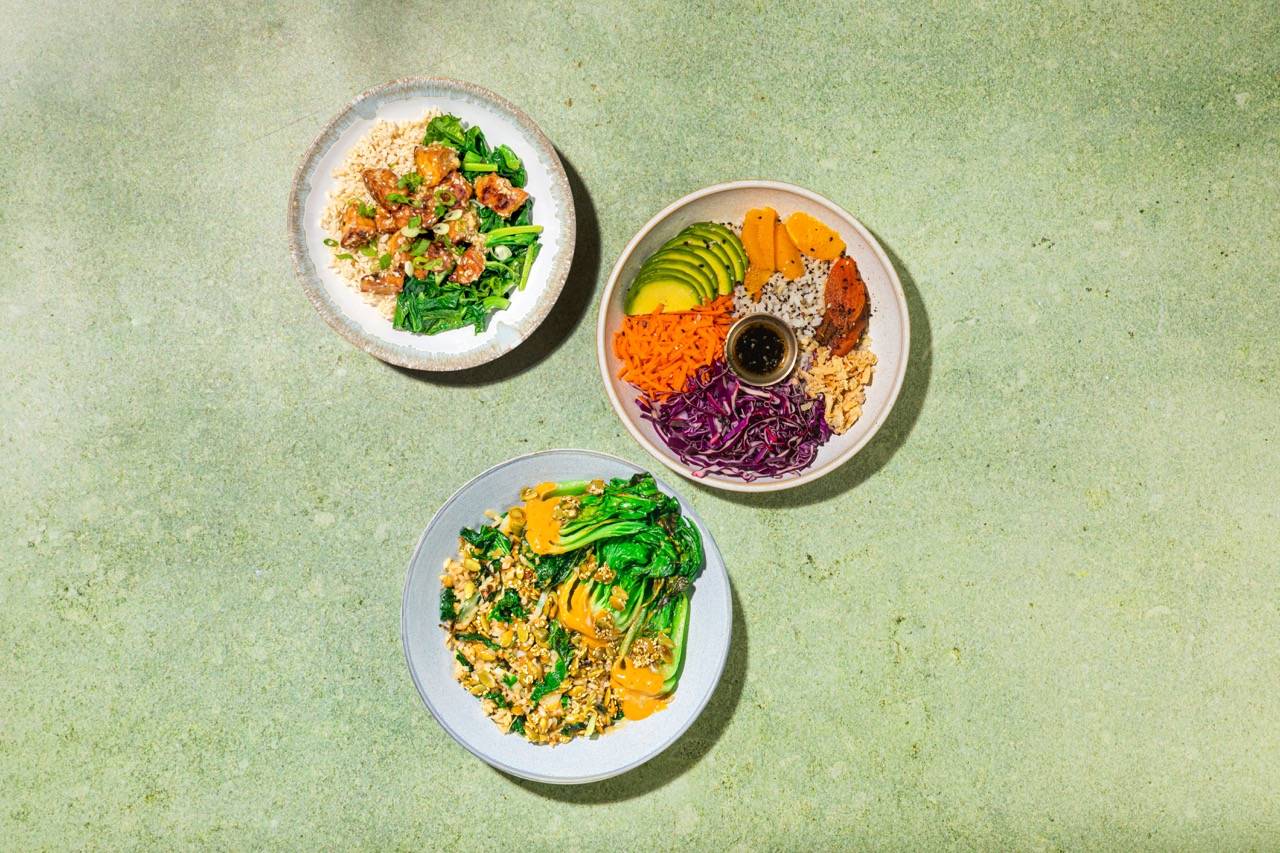 Three plates of colorful plant-based meals