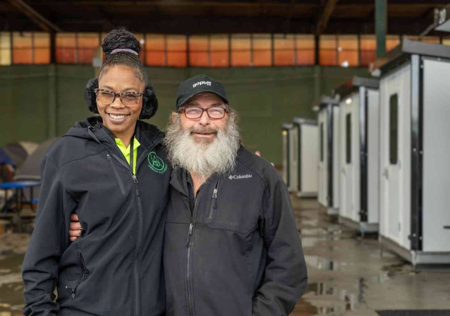 Two people standing in front of tiny homes