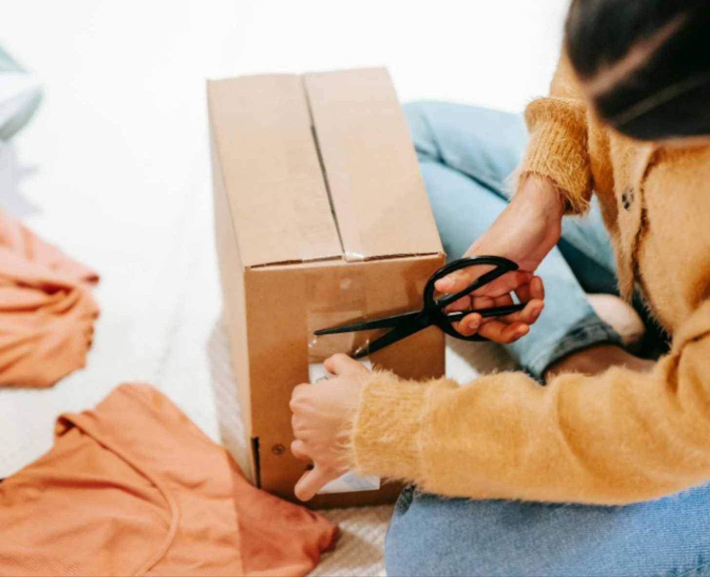 Person taping a package shut and cutting excess tape