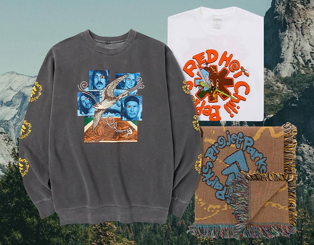 Red Hot Chili Peppers-graphic Grey crewneck sweatshirt, white folded t-shirt, and folded fringe brown blanket mocked up on top of a scenic mountain photo 