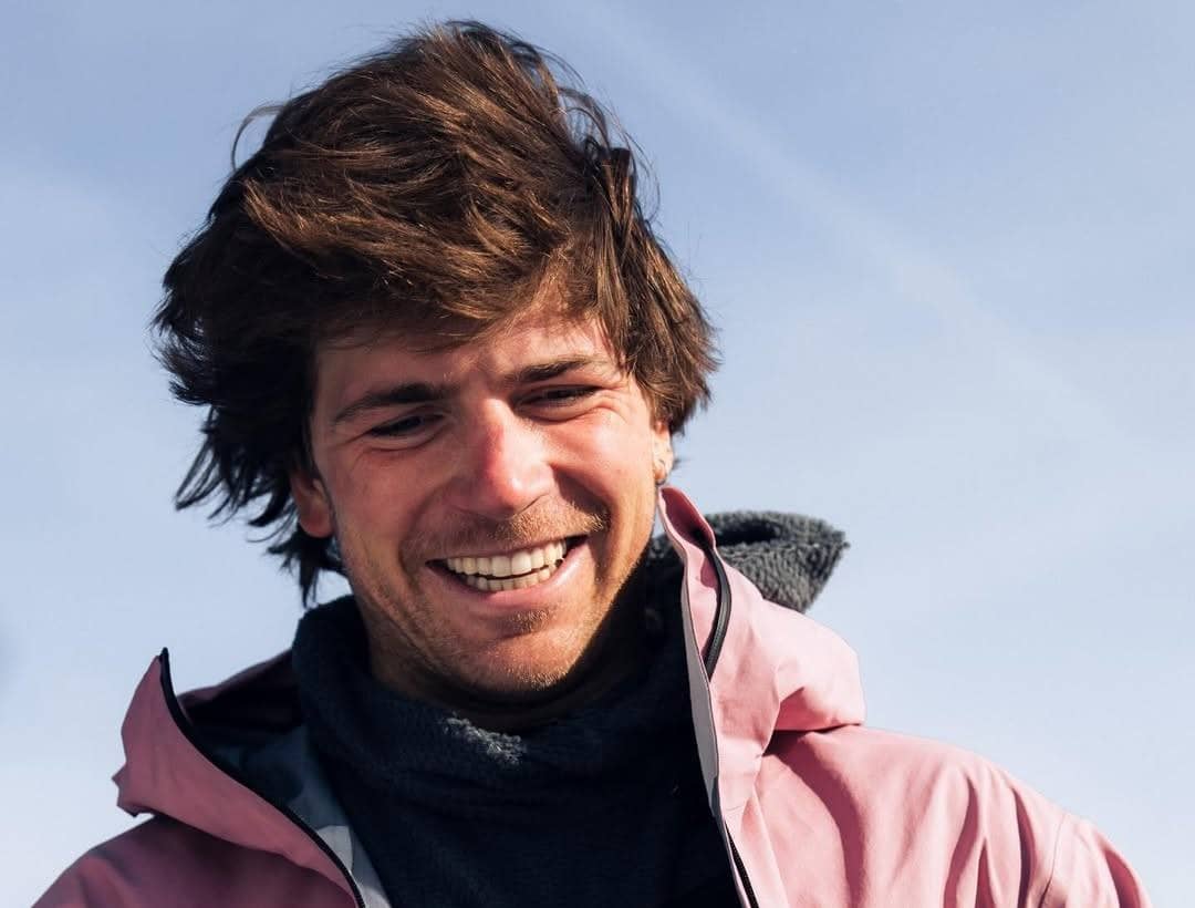 Hunter Hess smiling outdoors, wearing a pink winter jacket