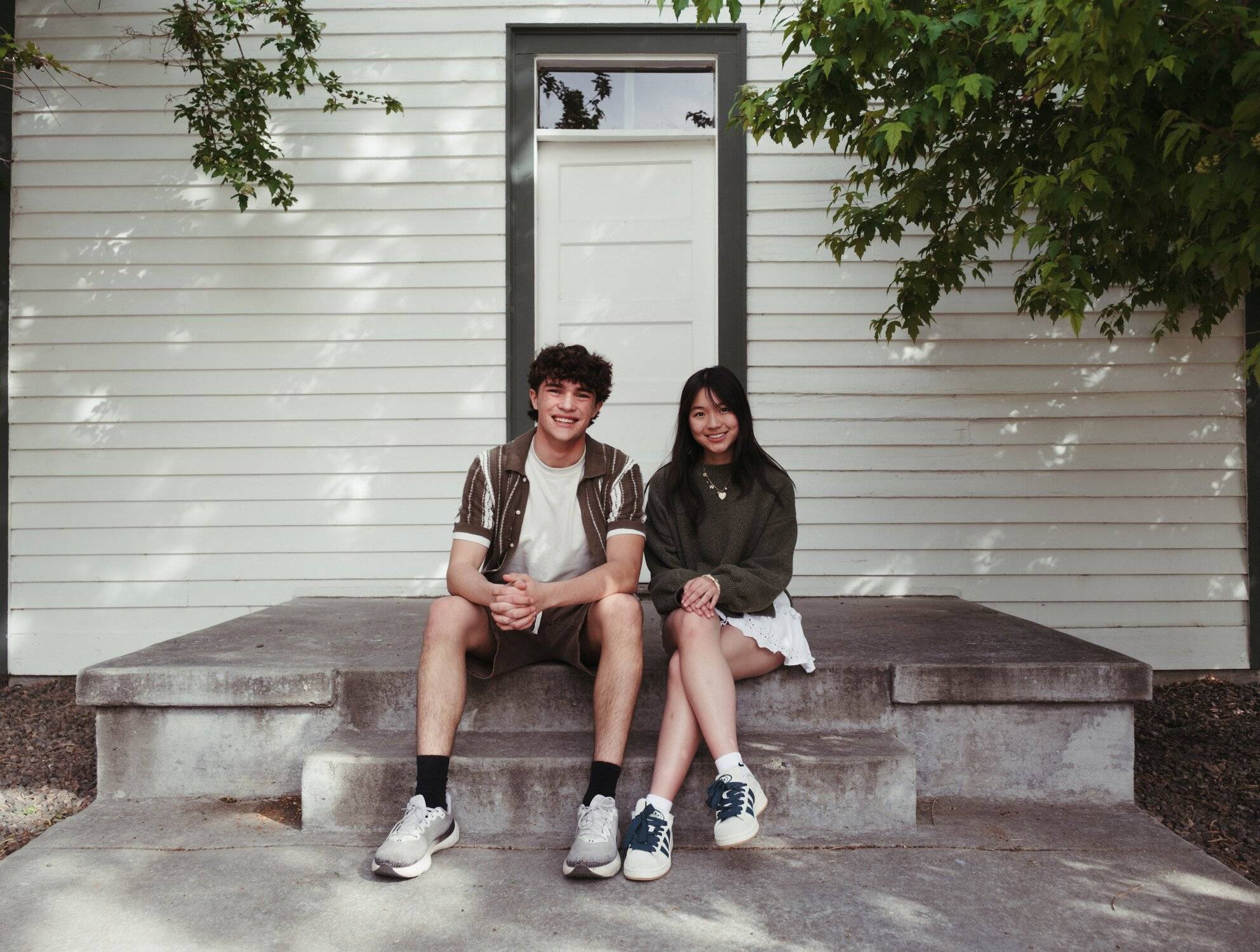 Two people sitting on a concrete stoop