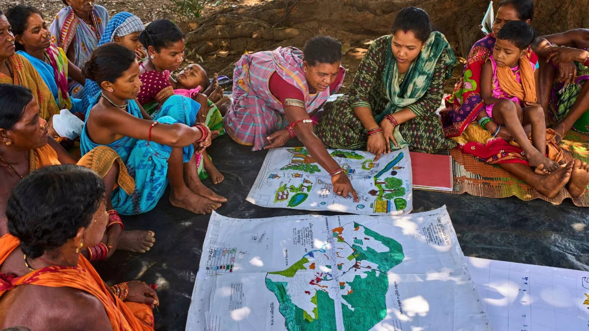 Women sitting around map drawings