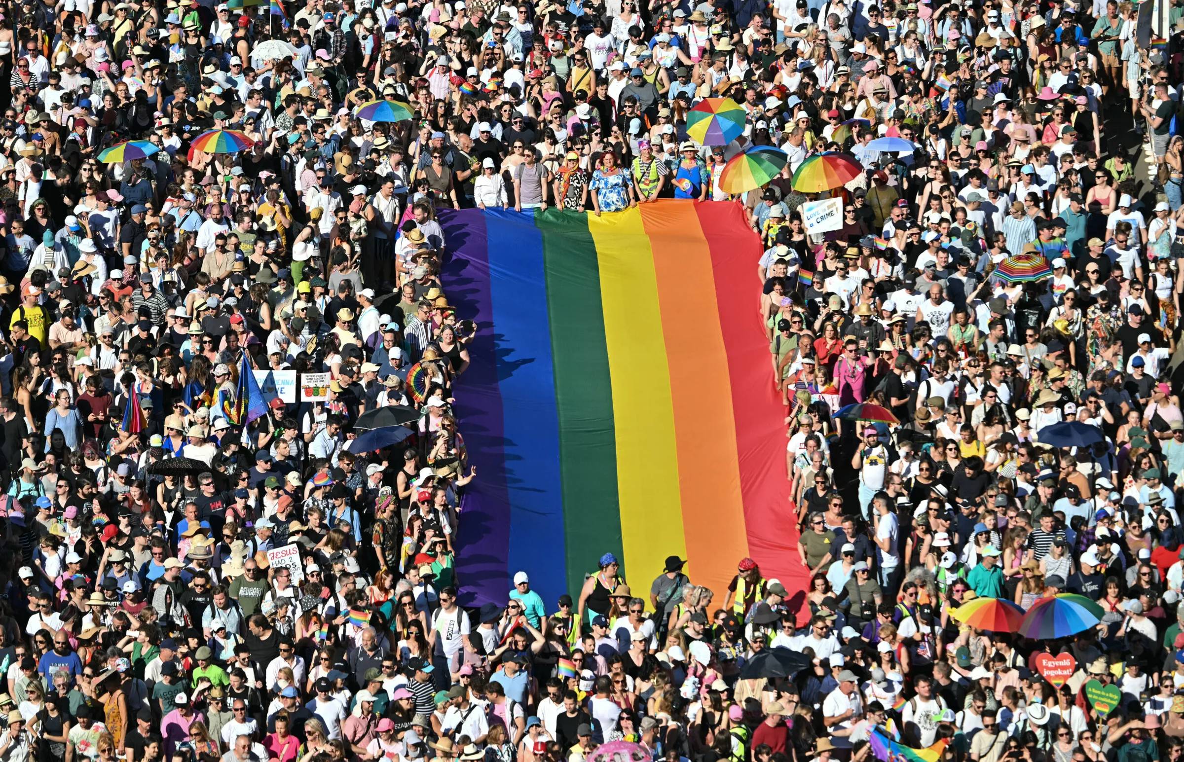 Large rainbow flag in the middle of a huge crowd