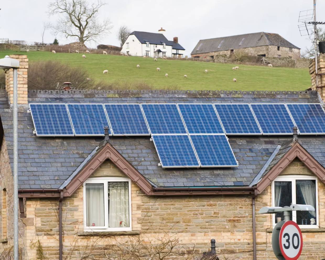 Ten solar panels on the roof of an older brick home