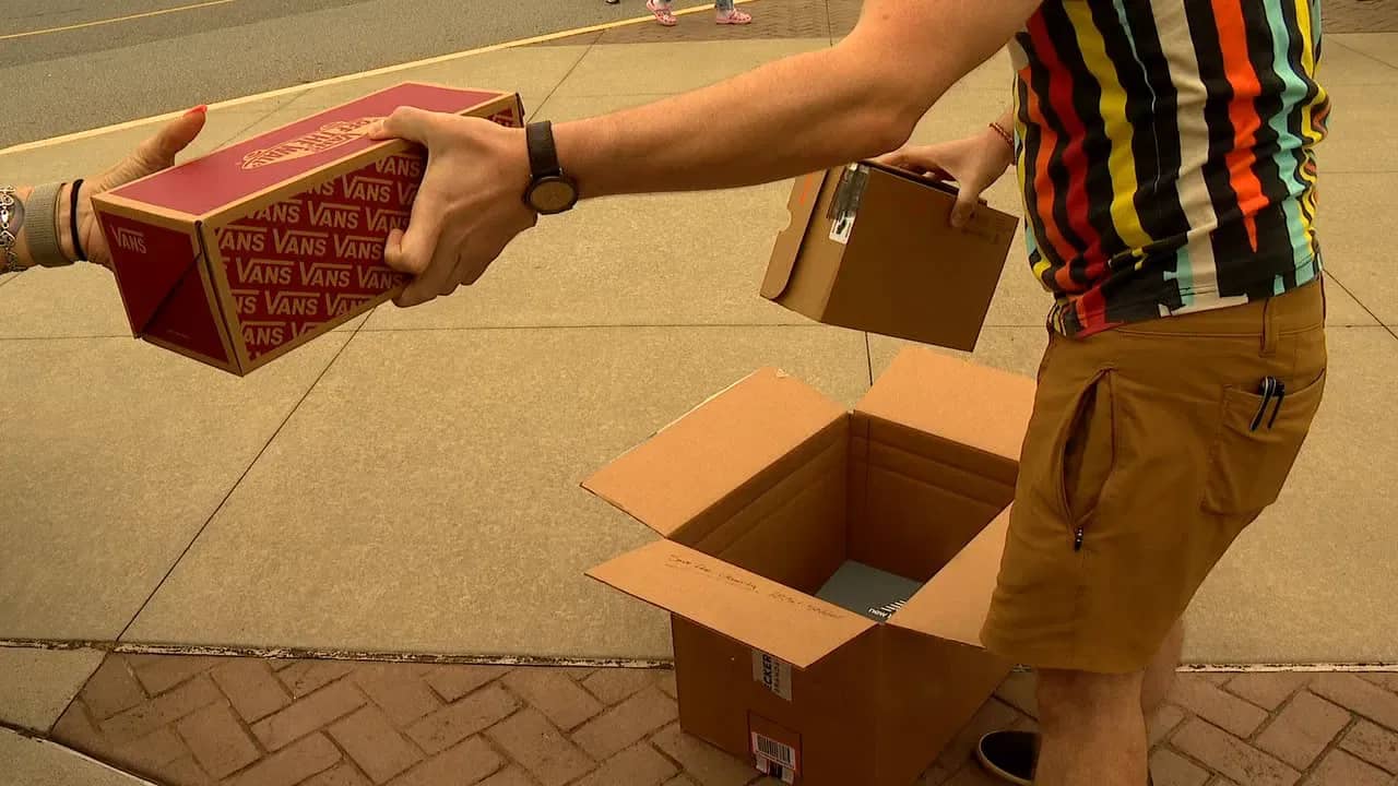 A person getting boxes of shoes out of a larger shipping box